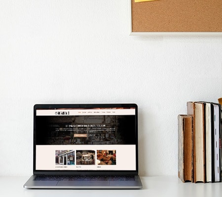 laptop met website op bureau met boeken
